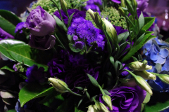 Vibrant floral arrangement featuring purple roses, lisianthus, and greenery, showcasing Antaeus Flowers' floral design expertise.